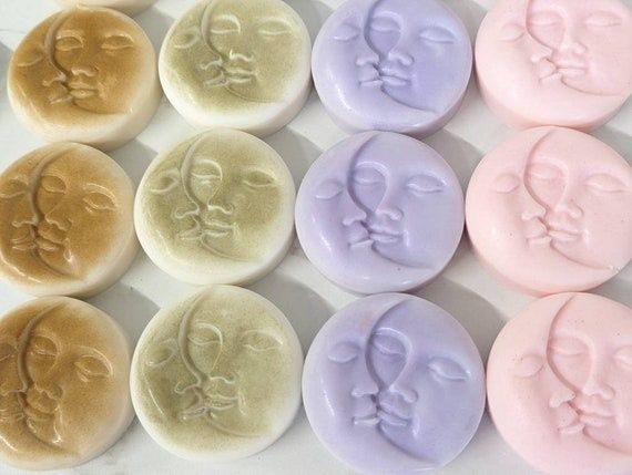 Runda fasta tvålbitar i pastellfärger, präglade med ansikten